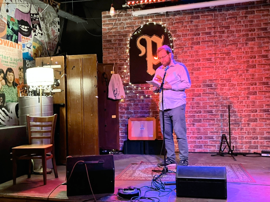 Thierry reading on stage at the Roath Writers 2025 Book Launch